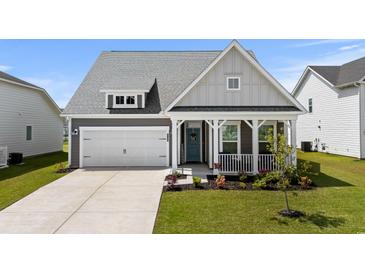 Charming home with a well-manicured lawn, a covered porch, and an attached garage at 2105 Ballast Ct., Myrtle Beach, SC 29579