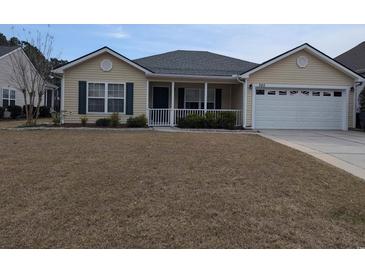 Inviting one-story home featuring manicured lawn, attached garage, and a charming front porch at 320 Mckaylas Ct., Myrtle Beach, SC 29579