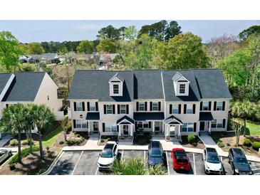 Inviting townhomes feature black shutters, gray roof, and well-maintained landscaping, with ample parking for residents and guests at 100 Barnacle Ln. # S-4, Little River, SC 29566