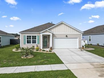 Charming one-story home with a well-manicured lawn and a two-car garage on a sunny day at 1612 Cosmos Lane, Myrtle Beach, SC 29577
