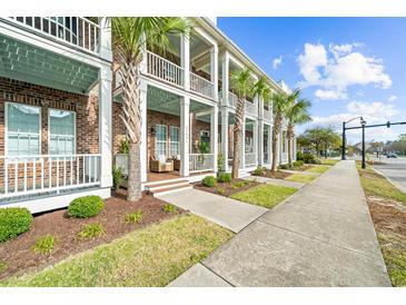 Charming townhouse exterior with brick facade, white columns, and breezy balconies lined with lush palm trees at 2790 Howard Ave. # D, Myrtle Beach, SC 29577