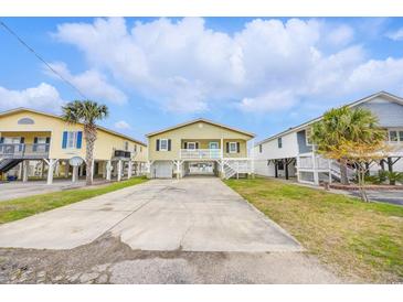 Charming raised beach house with a spacious driveway and manicured landscaping at 308 36Th Ave. N, North Myrtle Beach, SC 29582