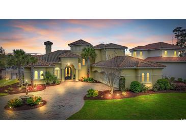 Stately Mediterranean home with tile roof, manicured landscaping, and paver driveway at sunset at 9243 Marina Pkwy., Myrtle Beach, SC 29572