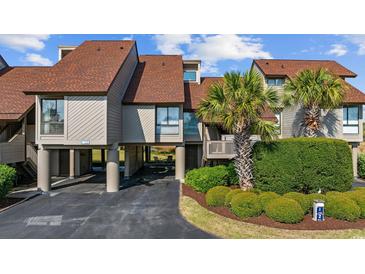 Beautifully landscaped townhouse featuring a modern design with a well-manicured lawn and a spacious driveway at 12 Spartina Ct. # 2, Pawleys Island, SC 29585