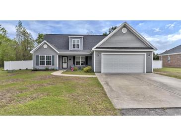 Charming one-story home featuring gray siding, a well-manicured lawn, and an attached two-car garage at 1794 Graham Rd., Aynor, SC 29544