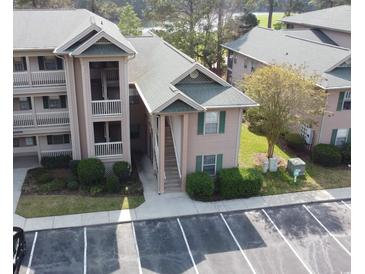 Beautiful condo building with two-story access stairs, lush landscaping, and ample parking at 524 Pinehurst Ln. # 19D, Pawleys Island, SC 29585
