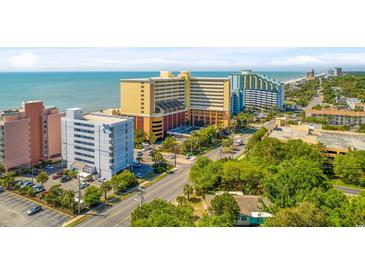 Aerial view of resort buildings, lush landscaping, roads, parking, and the ocean in the background at 6900 N Ocean Blvd. # 735, Myrtle Beach, SC 29572