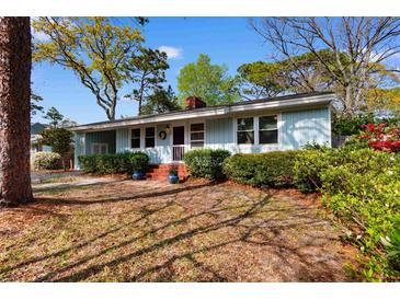 Charming one-story home featuring blue siding, mature landscaping and a brick porch at 708 48Th Ave. N, Myrtle Beach, SC 29577