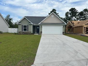 Charming single-story home boasts a gray roof, a well-manicured lawn, and a two-car garage at 933 Padgett Lane, Conway, SC 29526