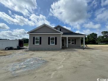 New construction home with gray siding, black shutters, and a covered entryway at 334 William Nobles Rd., Aynor, SC 29511