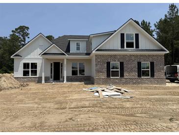 Two-story home with a brick facade, white siding, black shutters and an unfinished front yard at 346 Ridge Rd., Galivants Ferry, SC 29544