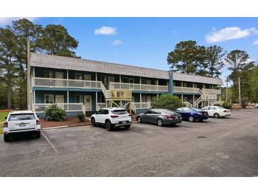 Charming two-story condo building with lots of parking and a stairway to the balcony at 610 Putters Ln. # H-109, Little River, SC 29566