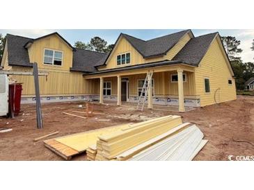 Spacious new construction home with yellow siding, a covered porch, and visible construction materials at 804 Edisto Ct., Myrtle Beach, SC 29588