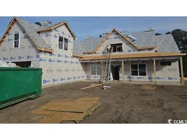Unfinished house exterior with wrap, windows, and a dumpster in the foreground, indicating an active construction site at 804 Edisto Ct., Myrtle Beach, SC 29588