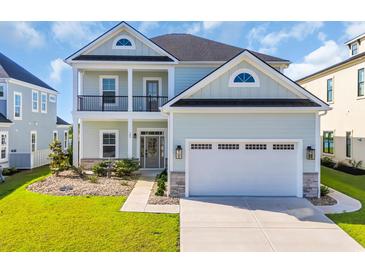 Two-story home featuring a two-car garage, covered porch, black trim and a manicured lawn at 186 Palmetto Harbour Dr., North Myrtle Beach, SC 29582