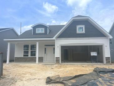 Charming single-story home with a two-car garage, stone accents, and light gray siding at 1105 Nw Forest Bend Dr., Calabash, NC 28467