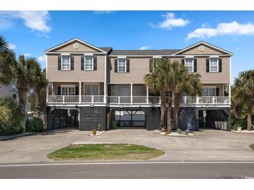Inviting exterior elevation featuring tropical landscaping and stilt construction, ideal for coastal living at 1210 A S Ocean Blvd., Surfside Beach, SC 29575