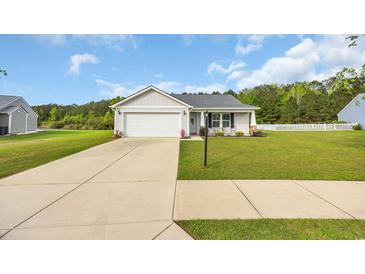 Charming single-story home featuring a well-manicured lawn, white picket fence, and attached two-car garage at 1340 Valor Rd., Conway, SC 29527