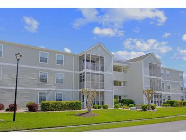 Attractive condominium building featuring screen enclosed balconies and manicured landscaping at 1950 Bent Grass Dr. # K, Surfside Beach, SC 29575