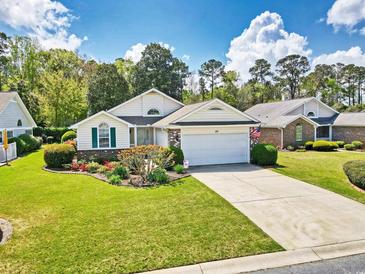 Charming single-story home featuring a well-manicured lawn and an attached garage with an inviting driveway at 25 Bentley Ct., Pawleys Island, SC 29585