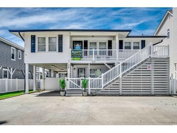 Two story beach house featuring elevated structure, white siding, and a double staircase at 329 46Th Ave. N, North Myrtle Beach, SC 29582
