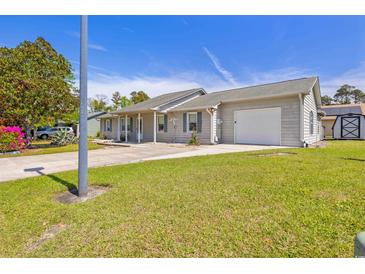 Charming single-story home with a well-maintained lawn, long driveway and attached two-car garage at 349 Robin Hood Circle, Little River, SC 29566