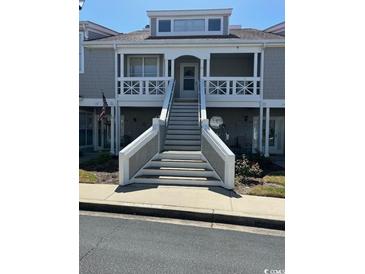 Exterior of townhome with prominent staircase leading to the main entrance at 4396 Baldwin Ave. # C-24, Little River, SC 29566