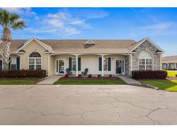 Inviting single-story home featuring neutral siding, stone accents, charming front porch, and well-maintained landscaping at 621 Banks Dr. # 12-1, Myrtle Beach, SC 29588