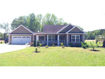 Charming single-story home with a well-manicured lawn and attached two-car garage at 1210 Horry Rd., Aynor, SC 29511