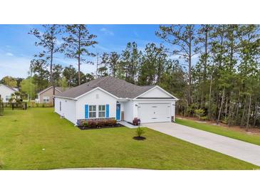 Charming home with a well-manicured lawn and a two-car garage is surrounded by lush trees at 3004 Fiddler Ct., Loris, SC 29569