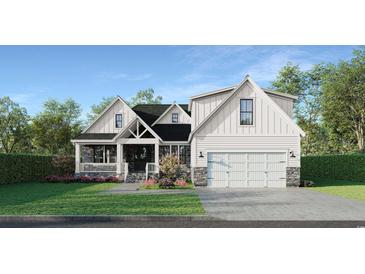 Charming new construction home with white siding, stone accents, and a well-manicured front lawn at 348 Autumn Pheasant Loop, Calabash, NC 28467