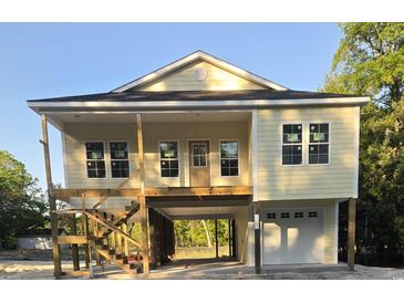 New construction home featuring a raised foundation, front porch, and garage at 4831 Riverside Dr., North Myrtle Beach, SC 29582