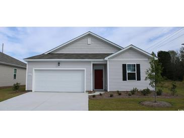 Charming single-Gathering home with a well-manicured lawn, attached garage, and a classic red front door at 1439 Nokota Dr., Conway, SC 29526