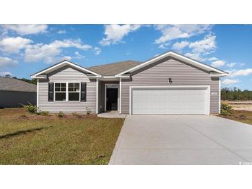 Charming single-story home featuring a two-car garage, tidy lawn, and attractive gray siding at 1446 Nokota Dr., Conway, SC 29526