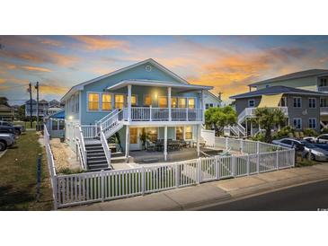 Charming two-story beach home with a white picket fence and spacious covered porch, perfect for coastal living and entertaining at 1512 S Ocean Blvd., North Myrtle Beach, SC 29582