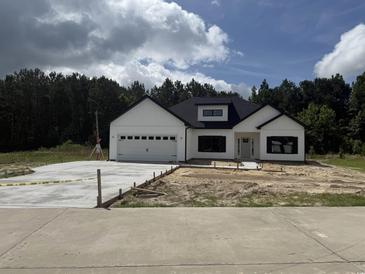 Charming new construction with white siding, black trim, and a spacious driveway at 204 Shady Pines Ct., Conway, SC 29527