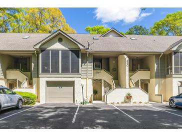 Charming condo with garage, stairs to entrance, neutral colors, and well maintained grounds at 220 Clubhouse Dr. # 20B, Sunset Beach, NC 28468