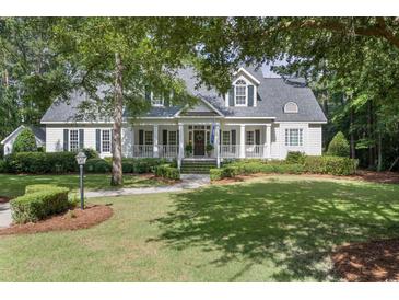 Charming two-story home with a well-manicured lawn and inviting front porch at 4218 Vanderbilt Dr., Pawleys Island, SC 29585