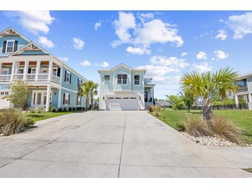 Charming, light blue two-story home with an attached two-car garage and a concrete driveway at 422 Harbour View Dr., Myrtle Beach, SC 29579