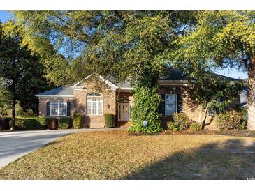 Charming brick home featuring a manicured lawn and lush greenery, creating an inviting curb appeal at 808 East Coast Ln., North Myrtle Beach, SC 29582