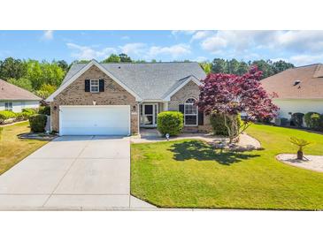 Charming brick home featuring a well-manicured lawn and a vibrant Japanese maple tree at 174 Seville Dr., Murrells Inlet, SC 29576