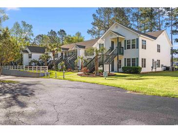 Inviting two-story condo complex featuring lush landscaping and private staircases to each unit at 820 Fairway Dr. # 1506Hh, Longs, SC 29568