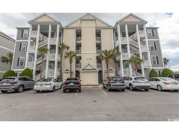 Condo exterior featuring multiple units, covered stairwells, and parking at 118 Ella Kinley Circle # 404, Myrtle Beach, SC 29588