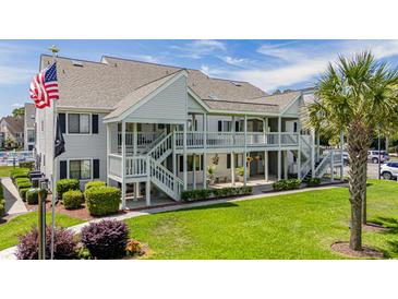 Inviting condo complex featuring a two-story building, well-maintained landscaping, and a communal pool at 1880 Auburn Ln. # 27 A, Surfside Beach, SC 29575