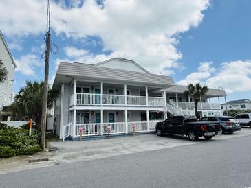 A two-story condo building with white railing around the balconies, with blue sky and clouds above at 202 28Th Ave. N # 5, North Myrtle Beach, SC 29582