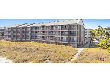 Beachfront condo building with multiple levels of screened in porches, close beach access, and beautiful landscaping at 208 Ocean Blvd. N # 228, North Myrtle Beach, SC 29582