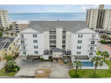 An aerial shot of a white condo building with blue shutters, a pool, and beach access at 2406 S Ocean Blvd. # 301, North Myrtle Beach, SC 29582