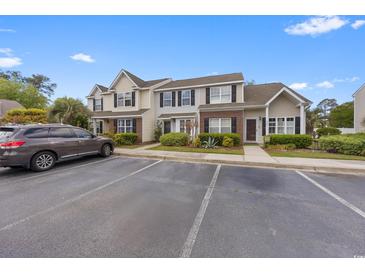 Townhome exterior showing parking, landscaping, and classic design with brick accents at 3563 Chestnut Dr. # 3563, Myrtle Beach, SC 29577
