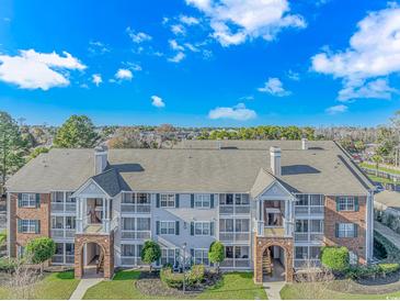 Beautiful condo building with gray siding, brick accents, and well-maintained landscaping at 3795 Hitchcock Way # 617, Myrtle Beach, SC 29577