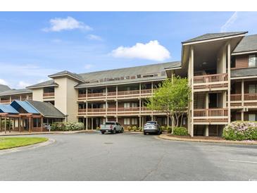 Condo exterior with multi-level balconies, covered entryway, and ample parking at 410 Melrose Pl. # 110, Myrtle Beach, SC 29572